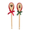 Due porta mestolo in silicone con cucchiai in legno della collezione Bear Wonderland di Nuvole di Stoffa. Uno ha un cucchiaio con un'incisione a forma di cuore e un nastro rosso, l'altro ha un cucchiaio con un'incisione a forma di albero di Natale e un nastro verde.