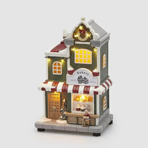 Boutique Bakery natalizia illuminata con luci LED e accompagnata da musica, decorata con dettagli festivi e una figura di Babbo Natale all'esterno.