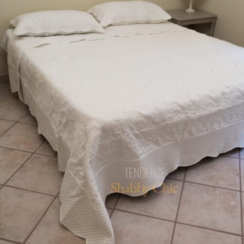 Copriletto matrimoniale bianco in stile boutis con dettagli floreali e federe abbinate, ideale per ambienti eleganti e luminosi