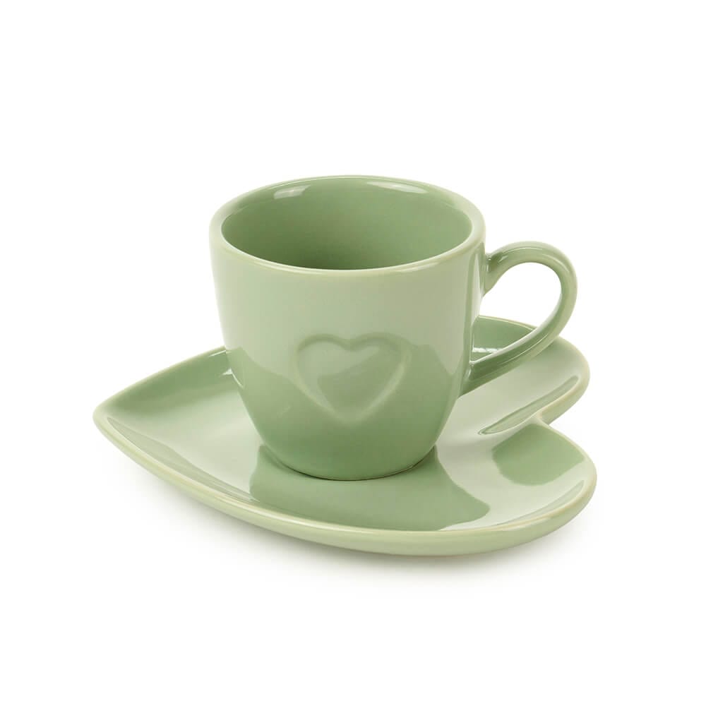 Tazzina da caffè in ceramica verde con cuore in rilievo e piattino a forma di cuore, ideale per pause caffè eleganti o romantiche.