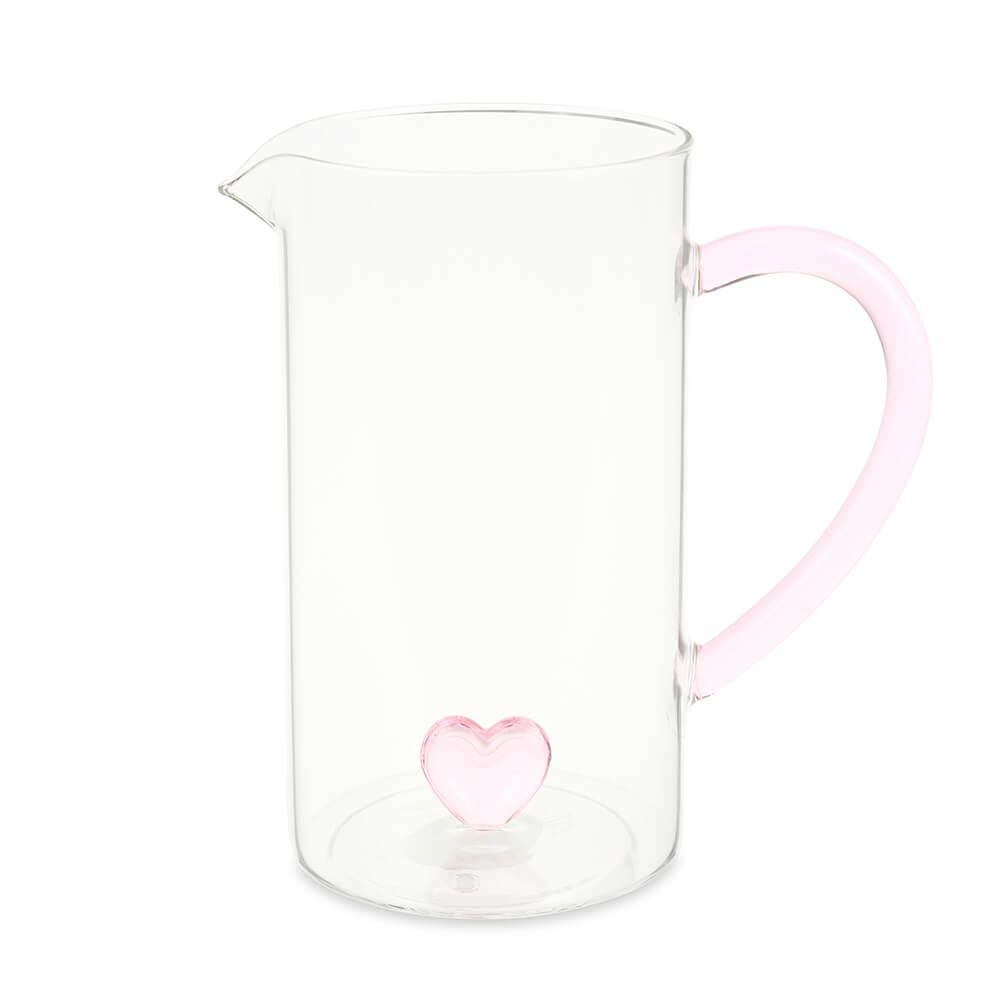 Brocca in vetro trasparente con cuore rosa alla base e manico in vetro rosa, ideale per servire bevande con stile e raffinatezza.