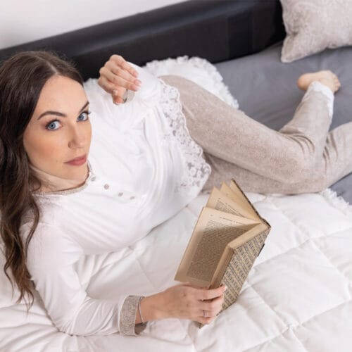 Pigiama due pezzi bianco e beige con dettagli in pizzo floreale e bottoncini decorativi, perfetto per un look elegante e rilassato.