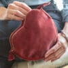 Pochette a forma di cuore in velluto rosa antico con nappina decorativa, elegante e raffinata.