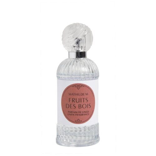 Bottiglia di profumo per tessuti Mathilde M. Fruits des Bois da 75 ml, posizionata in un cesto decorativo con bacche rosse e fragole, su uno sfondo naturale con dettagli floreali.