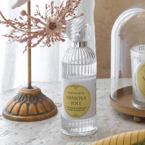 Flacone in vetro lavorato da 100 ml con profumo d’ambiente Mimosa Joli di Mathilde M., un’essenza raffinata con note di petitgrain, bergamotto e mimosa.