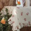 Mantel resinado beige con decoración floral y volante 155x185
