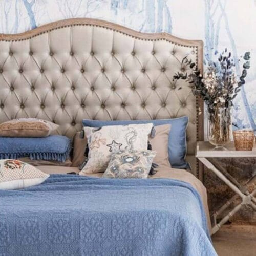Testata letto matrimoniale con imbottitura in lino naturale, lavorazione capitonné e cornice in legno di rovere con finitura anticata.