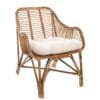 Poltroncina in rattan naturale con cuscino bianco, dallo stile mediterraneo e design arrotondato.