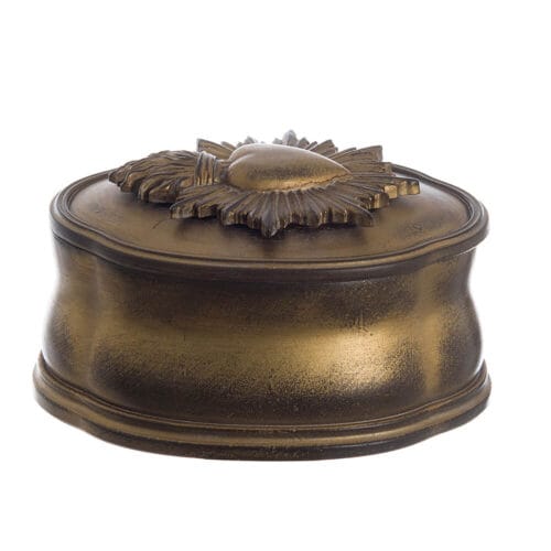 Cofanetto ovale in resina color bronzo anticato con coperchio decorato da ex voto a forma di cuore fiammato.