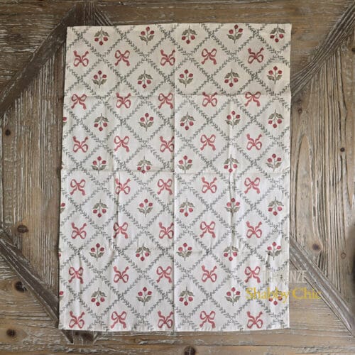 Canovaccio in cotone con stampa a griglia di fiocchi rossi e bacche su fondo chiaro, decorazione semplice ed elegante.