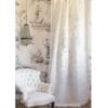 Tenda in lino e cotone bianco con ricamo medaglione centrale beige, appesa su fondo toile de Jouy.