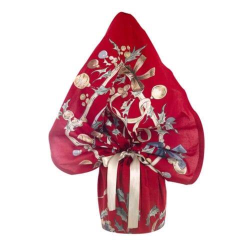 Copritavolo o confezione porta panettone in cotone rosso con stampa natalizia: fiocchi, palline e rami di agrifoglio in stile vintage.