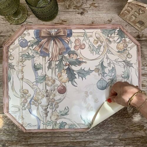 Tovaglietta in vinile ottagonale con sfondo crema, decoro natalizio vintage con fiocchi, palline e agrifogli. Finitura effetto legno.