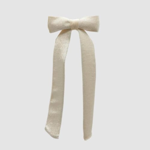 Fiocco in velluto avorio con nastri lunghi e clip posteriore in metallo, elegante e decorativo.