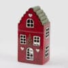Portacandela EDG in ceramica a forma di casetta rossa con tetto verde e finestrelle intagliate.
