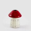 Portacandela EDG in ceramica a forma di fungo con cappello rosso e gambo bianco scanalato.