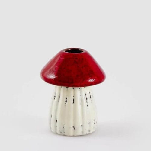 Portacandela EDG in ceramica a forma di fungo con cappello rosso e gambo bianco scanalato.