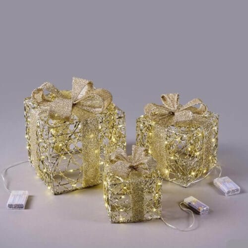 Tris di pacchi decorativi dorati con fiocco glitter e luci LED calde, struttura intrecciata in metallo, alimentazione a batteria.