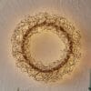 Corona decorativa luminosa in metallo dorato con intrecci di fili luminosi e 936 microled, da appendere.