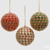 Set di 3 palle natalizie EDG da 10 cm con decori floreali su base rossa, bianca e verde, confezionate in scatola regalo.