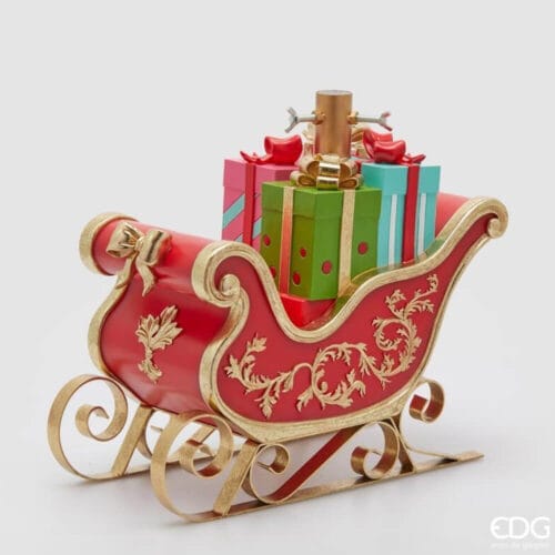 Base per albero EDG a forma di slitta natalizia rossa con finiture oro e pacchi regalo colorati.