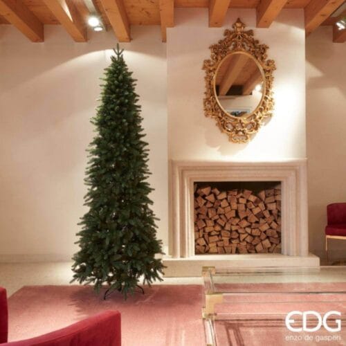 Albero di Natale artificiale EDG alto e slim, con folta chioma verde e struttura stabile, posizionato in un elegante salotto.