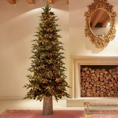 Albero di Natale artificiale EDG alto 180 cm con aghi realistici, illuminato da 2000 luci LED calde e base in stile tronco.