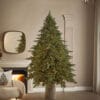 Albero di Natale EDG Pino Imperial New con 2500 luci calde e aghi effetto reale, ambientato in un salotto moderno con camino acceso.