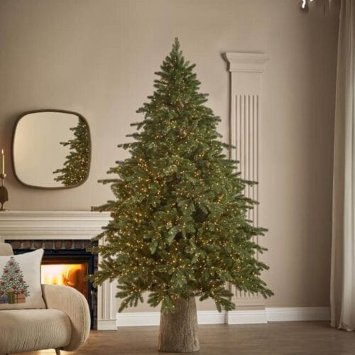 Albero di Natale EDG Pino Imperial New con 2500 luci calde e aghi effetto reale, ambientato in un salotto moderno con camino acceso.