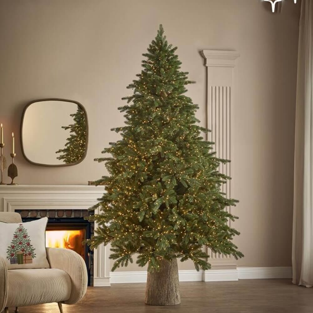 EDG Arbre de Noël Pin Impérial Nouveau avec 4000 lumières LED chaudes et des branches réalistes, placé dans un salon classique avec une cheminée allumée.