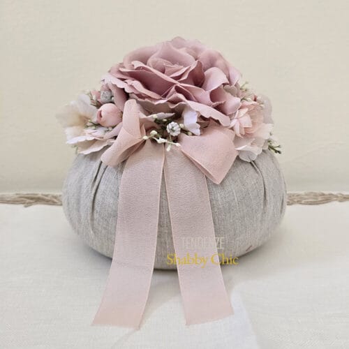 Pouf decorativo Fiori di Lena in lino naturale con fiori rosa cipria e fiocco, ideale come bonbon shabby chic per eventi eleganti.