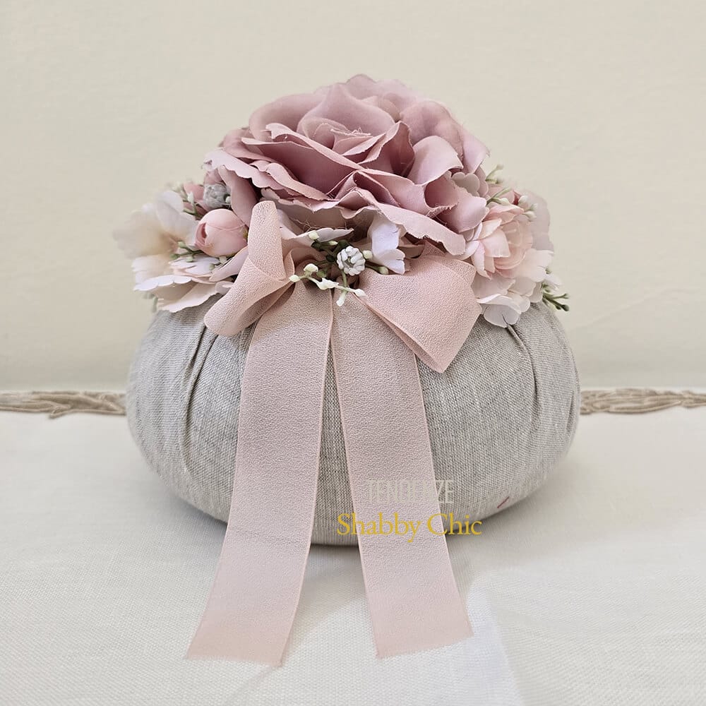 Pouf decorativo Fiori di Lena in lino naturale con fiori rosa cipria e fiocco, ideale come bonbon shabby chic per eventi eleganti.
