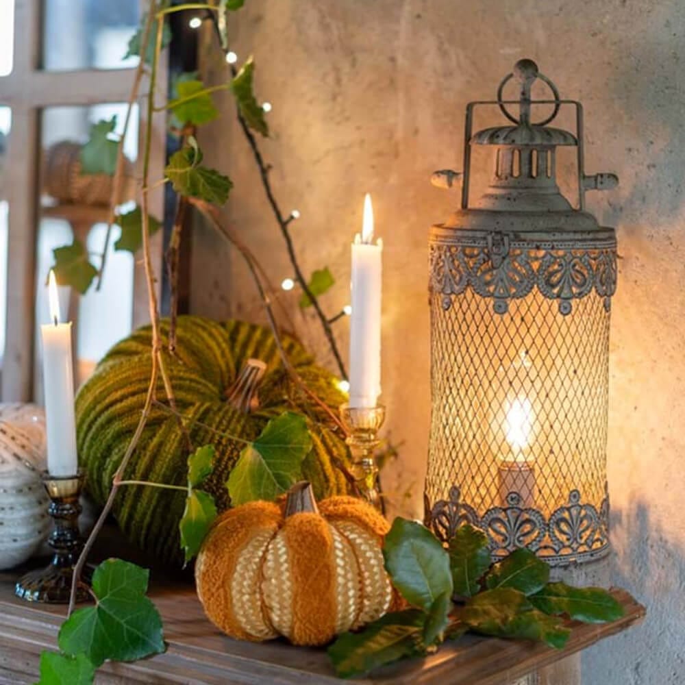 Lanterna decorativa in metallo brunito con rete traforata e luce LED interna, stile vintage, forma cilindrica.