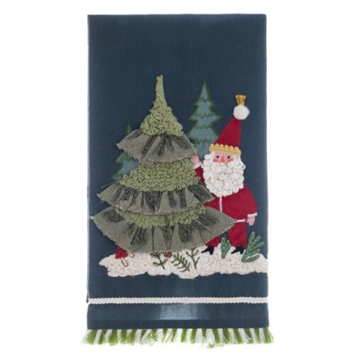 Canovaccio natalizio con sfondo blu e ricami di Babbo Natale accanto a un albero decorato con balze e dettagli tessili.