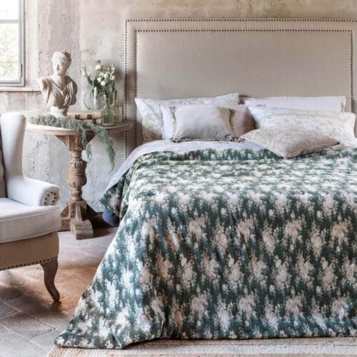 Trapunta matrimoniale verde con motivo floreale beige in rilievo effetto velluto, disposta su letto elegante in ambiente shabby chic.