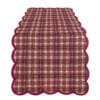 Runner in cotone con fantasia tartan rosso e bordo ondulato, perfetto per decorazioni natalizie o ambienti rustici.