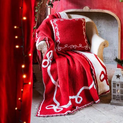 Plaid natalizio Blanc MariClo in sherpa rosso e bianco, con motivo jacquard double face e bordo decorato. Perfetto per il periodo natalizio.