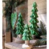 Tre alberi decorativi verdi con base in legno naturale e chioma smaltata, in stile bosco natalizio.