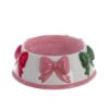 Ciotola per animali in ceramica bianca e rosa, con decori in rilievo a forma di fiocchi rosa, rossi e verdi.