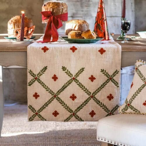 Runner natalizio in tessuto beige ricamato con motivo a losanghe verdi e croci rosse, bordo dorato intrecciato.
