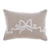 Cuscino rettangolare beige con ricamo centrale a fiocco bianco e bordatura tono su tono, in stile naturale.
