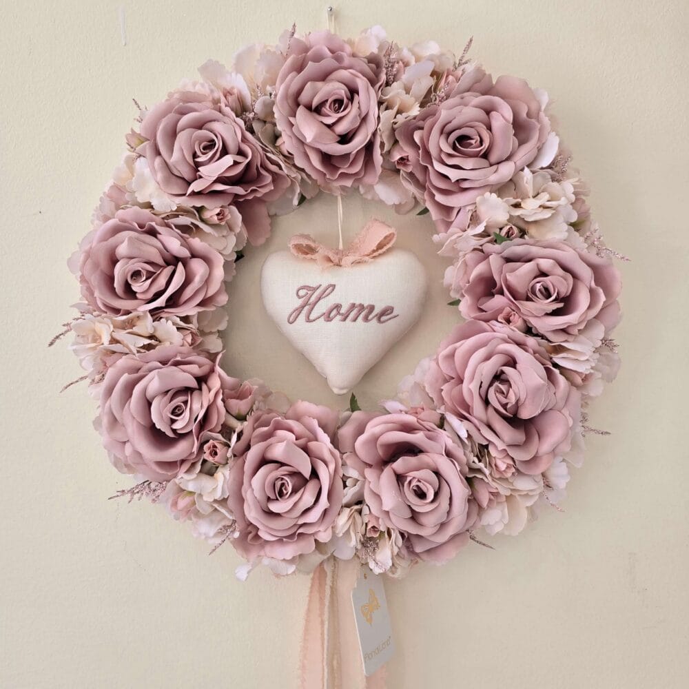 Ghirlanda Fiori di Lena con 8 rose cipria, ortensie, nebbiolina e cuore in tessuto ricamato con la scritta “Home”.