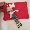 Pochette Fiori di Lena in lino rosso con portachiave bambolina Brigitte in denim, accessorio handmade spiritoso e femminile.