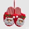 Addobbo natalizio in tessuto con due ciabatte rosse a righe e volto di Babbo Natale in feltro e peluche, con dettagli festivi.