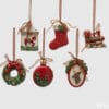 Set di sei decorazioni natalizie assortite in stile vintage con forme varie come trenino, ghirlanda e pallina, in rosso, verde e oro con fiocchi.