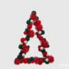 Decoro natalizio a forma di albero stilizzato con pompon rossi, verdi e bianchi e dettagli glitterati, con gancio in metallo per appenderlo.