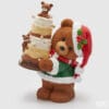 Statua natalizia in poliresina raffigurante un orsetto con cappello di Babbo Natale e torta a più piani decorata, con luci LED integrate.