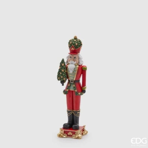 Statua natalizia in poliresina raffigurante un soldatino rosso con albero decorato e base con finiture dorate.