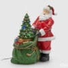 Figura decorativa di Babbo Natale con sacco verde pieno di regali e albero di Natale illuminato, con effetti luminosi e musicali.