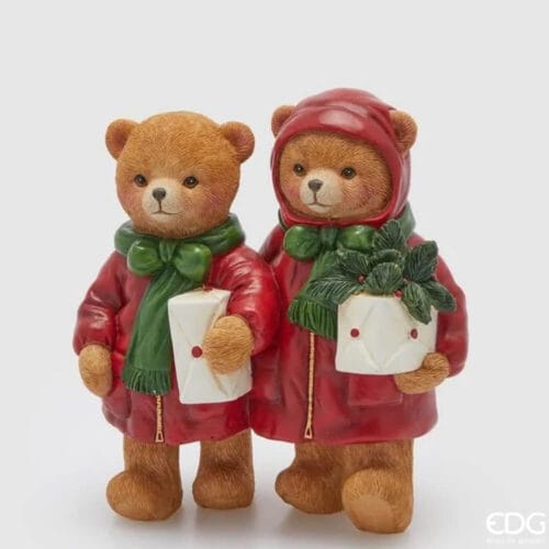Coppia di orsetti natalizi in poliresina con cappotti rossi, sciarpe verdi, buste regalo e una piantina festiva.